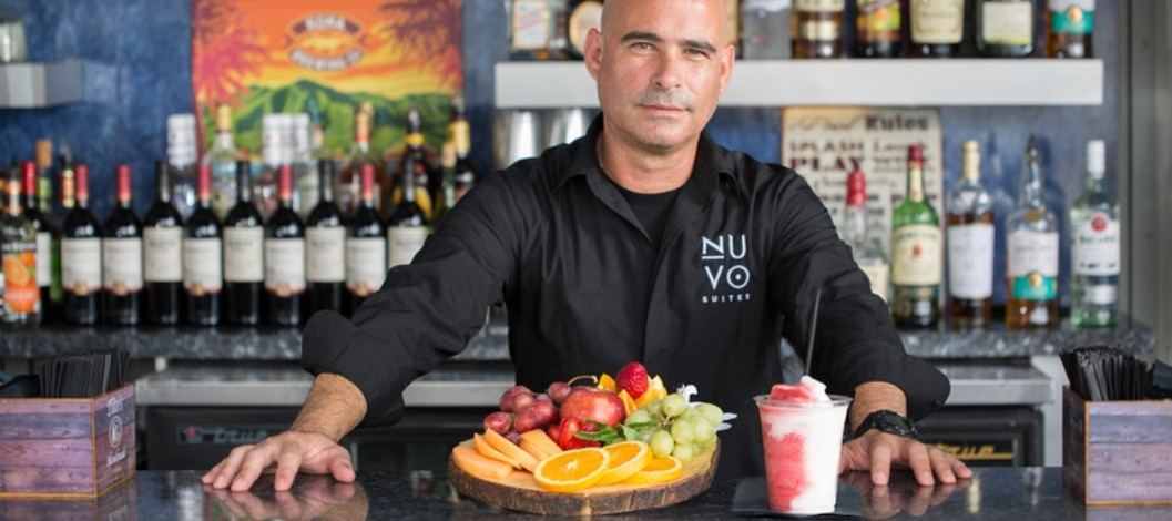 Bartender serving a plate of fruit and a frozen drink