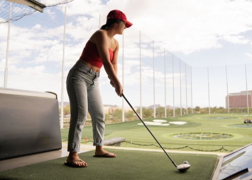 Mujer jugando al golf en un campo de prácticas