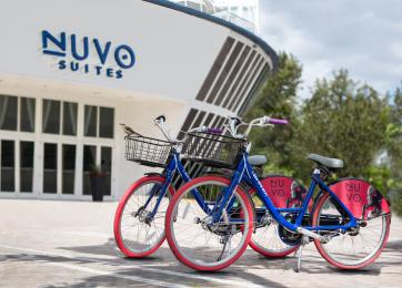 Duas bicicletas do Nuvo estacionadas em frente à entrada do Nuvo Suites