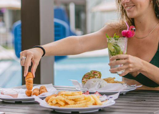 woman eating food from the pool bar