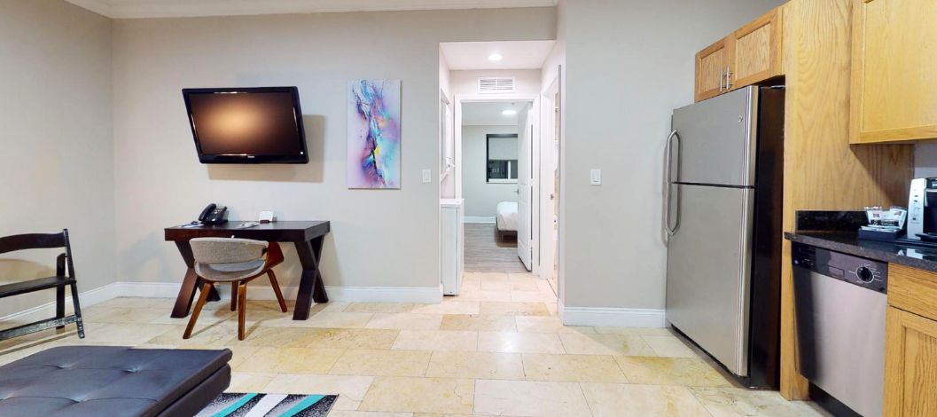 Sofá de cuero negro y mesa de café cerca de una cocina