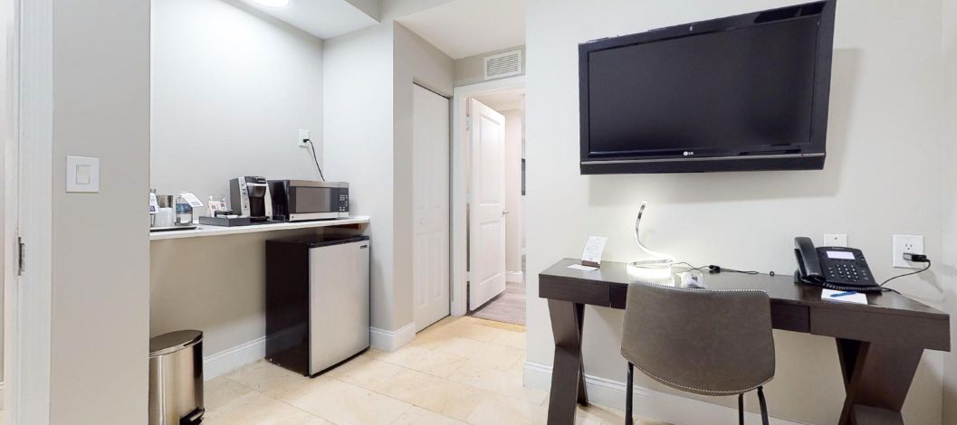 Cama king con cabecera de madera y mesillas de noche debajo de un cuadro