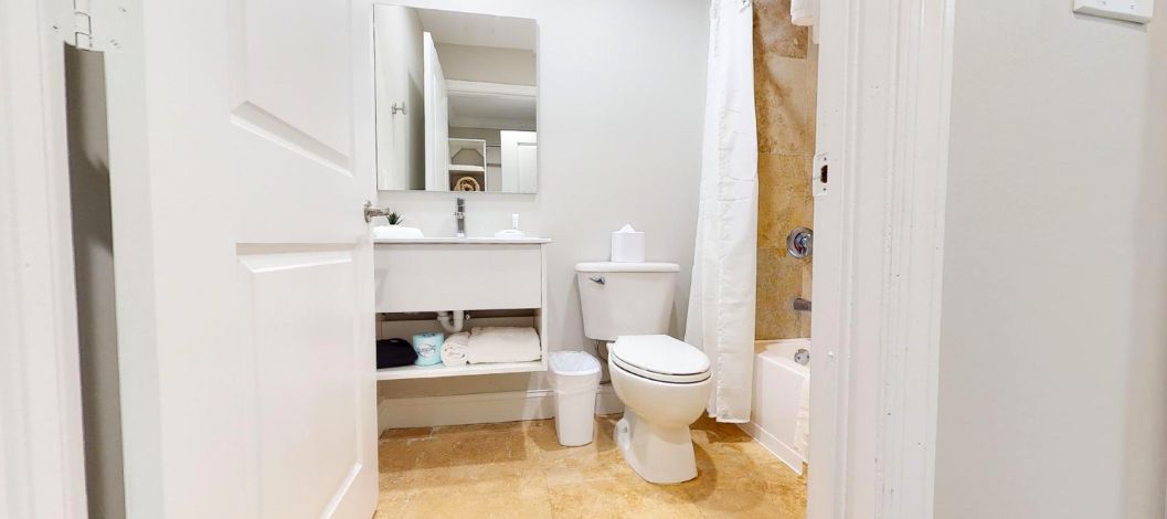 Inodoro, lavabo y espejo en un baño