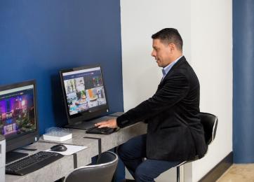 Área de estación de computadora con hombre sentado un escritorio